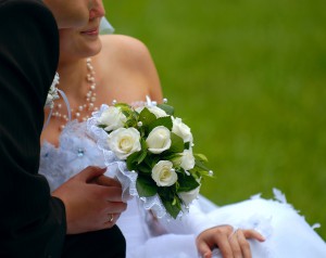 The groom with the bride and a bouquet close up