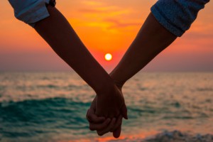 Couple Holding Hands at Sea Sunset